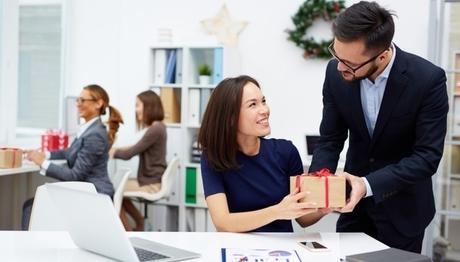 businessman giving his colleague christmas present