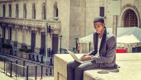 man working on pc sitting on roof top