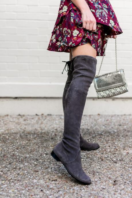 Amy Havins pairs a merlot floral dress with a gray over the knee boot.