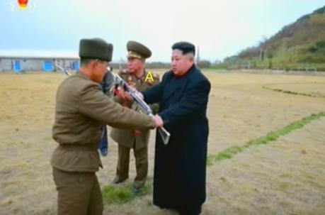Kim Jong Un presents a machine gun to a member of the island defense detachment. Also seen participating in the ceremony is Chief of the KPA General Staff VMAR Ri Myo'ng-su [A] (Photo: Korean Central Television).