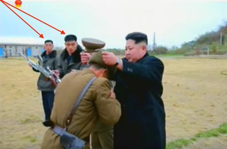 Kim Jong Un presents a pair of binoculars to a member of the islet defense detachment. Annotated are two members of Jong Un's bodyguard unit participating in the ceremony (Photo: Korean Central Television).