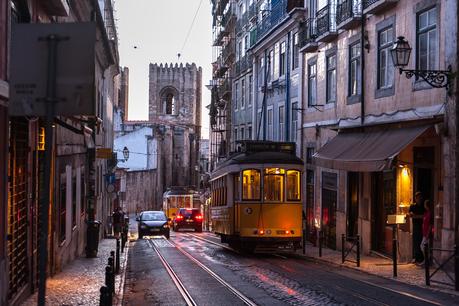 Tram crossing street at evening in Lisbon, Portugal