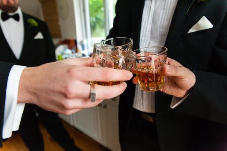 Groom has shots of whiskey in highball glasses before wedding