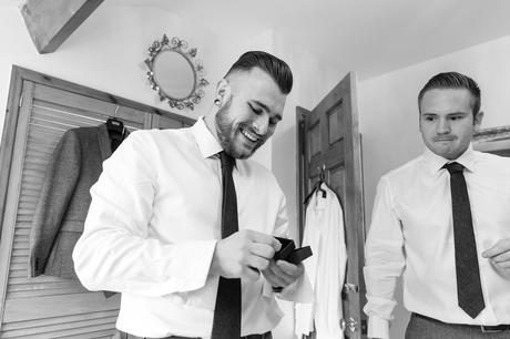 Groom with bald fade hair style smiles as he opens a gift