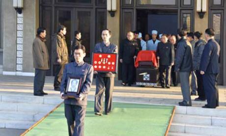 Departing for the cemetery, members of Ryu Mi-yo'ng's family carry her portrait and her state awards in front of her casket at the Sojang Center in Pot'onggang-kuyo'k in Pyongyang (Photo: KCNA).