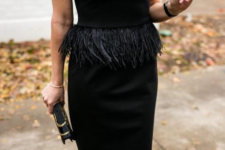 Amy Havins wears a black dress with feather accents from Camillyn Beth.