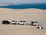 The convoy of Land Cruisers with the drivers have a break