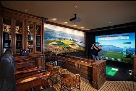 Man playing golf indoors on a golf simulator in his man cave