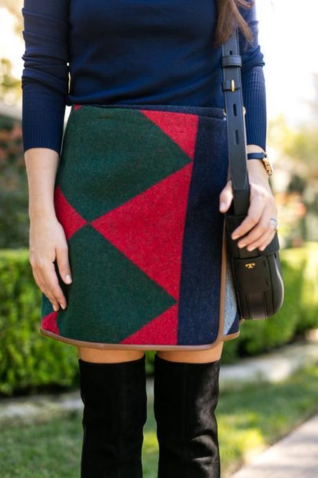 Amy Havins wears a tory burch color clocked skirt and over the knee boots.