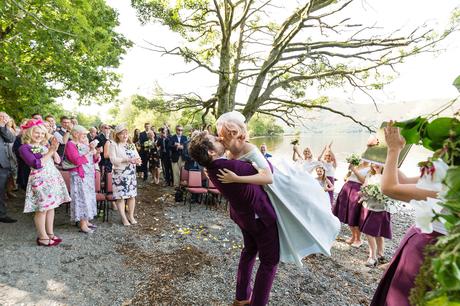 Groom picks up bride to kiss during the ceremony Derwentwater Independent Hostel Wedding