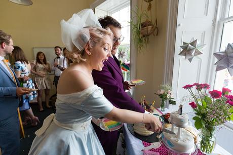 Bride in blue dress cutting the cake Derwentwater Independent Hostel Wedding
