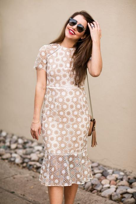 Amy Havins wears a Shoshanna cream and white lace midi dress.