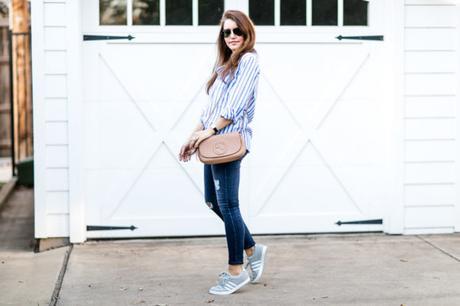 Amy Havins wears ripped jeans and a blue and white button down.