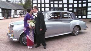 bride and groom outside Davenport Green Cheshire Hall with bride wearing Kimono and holding Orchids