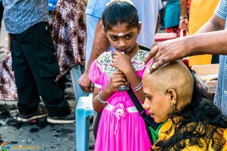 Mother having her head shaved as her daughter looks on, both in tears. Thaipusam 2017