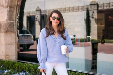 Amy havins wear a blue and white blouse with white jeans.