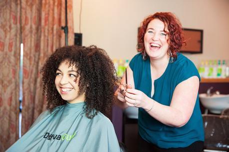 girl receiving natural curly hair cut