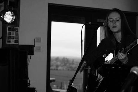 Image may contain: 1 person, sitting, playing a musical instrument and guitar