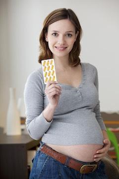 pregnant woman holding fish oil