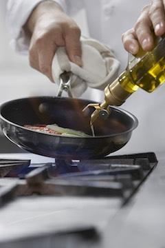 chef pour cooking oil in frying pan