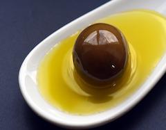 olive with olive oil on spoon