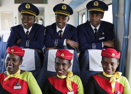 Kenya Railways train attendants (R) pose for a photograph inside one of the new passenger trains