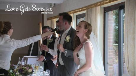 Groom singing in to the mic during Singing Waiters performance after meal at Willington Hall