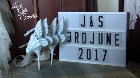 stunning white and blue butterfly Sophia Webster wedding shoes next to the wedding light bow with the wedding date