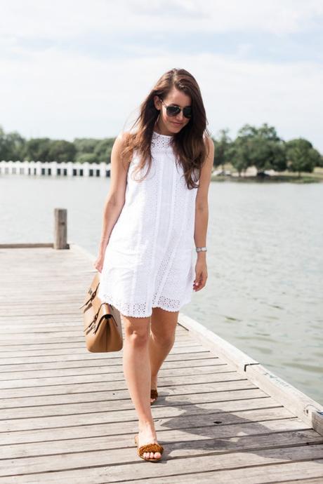 Amy Havins wears a white eyelet shift dress.