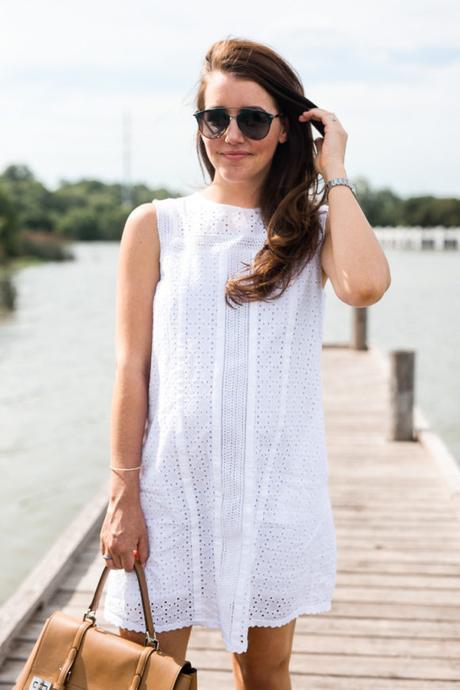 Amy Havins wears a white eyelet shift dress.