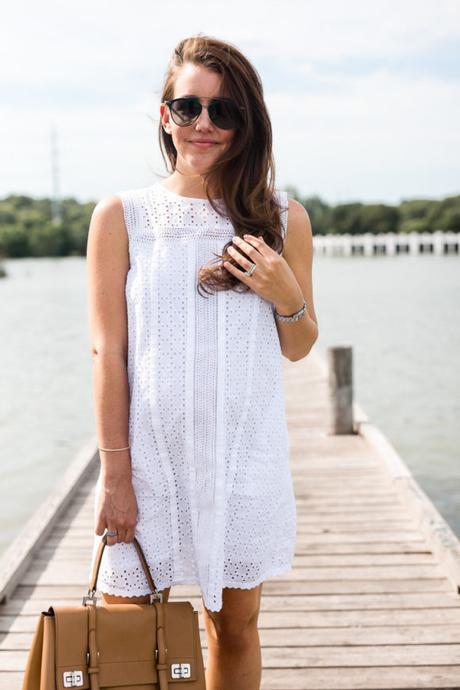 Amy Havins wears a white eyelet shift dress.