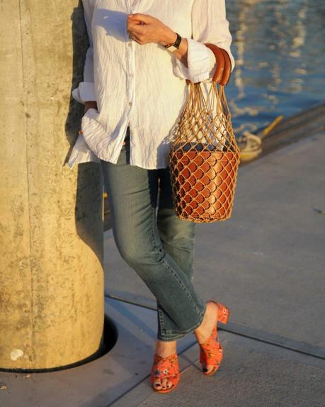 details: style blogger Susan B. wears Sam Edelman orange slide sandals and a Staud bucket bag. More at une femme d'un certain age.