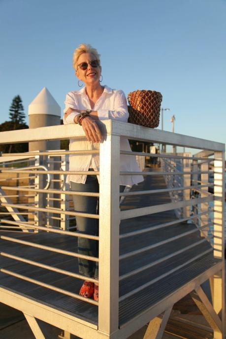 style blogger Susan B. wears a white linen shirt, orange Sam Edelman sandals