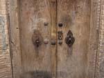 Wooden door displaying the two different knockers used depending on gender
