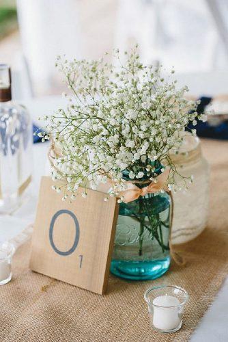 rustic wedding centerpieces bouquet of gypsophila flowers in blue mason jar with pink ribbon on natural tablecloth braun photography