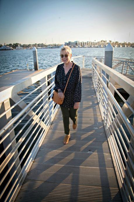Style blogger Susan B. wears a navy shirt, olive jeans and a camel J.Crew camera bag. 