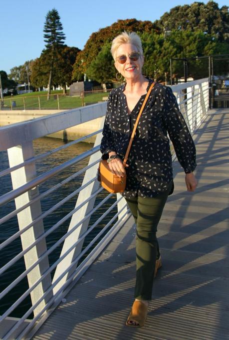 Style blogger Susan B. wears a printed silk top, olive jeans and a J.Crew crossbody bag