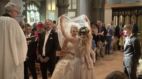 bridesmaid lifting the brides veil during their wedding ceremony at St Pauls in drighlington