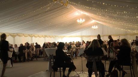 stunning marquee inside a working farm barn with fairy lights and a string quartet during the wedding breakfast