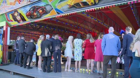 wedding guests waiting to have a go on the fairground dodgem bumper cars 