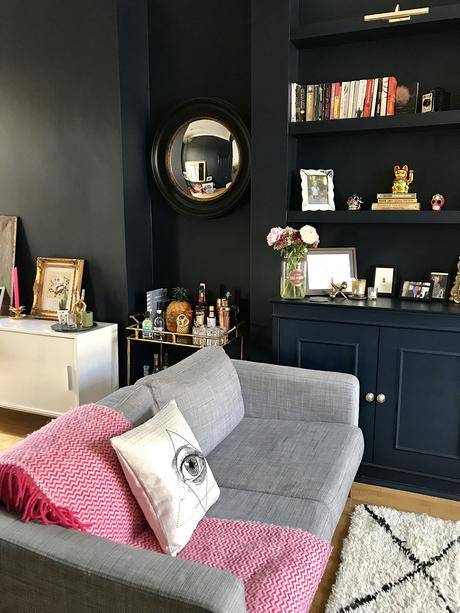 After: Living room transformation. Quirky and stylish home accessories give this dark and moody living room the wow factor. The walls are painted in Basalt by Little Greene, which works great with gold accents.