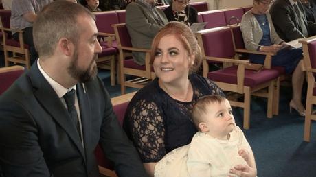 mum and dad sharing a moment with daughter sat on their lap at church in Rhyl