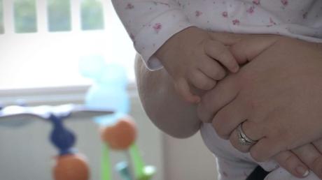 close up of baby girls hand holding her Mummy's hand at home