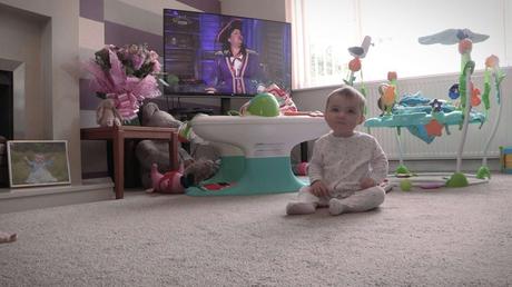 baby girl sat in her living room waiting for her mommy and daddy on video for her own christening video
