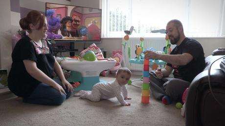 baby girl playing with parents in their home before getting ready for her Christening video in Rhyl