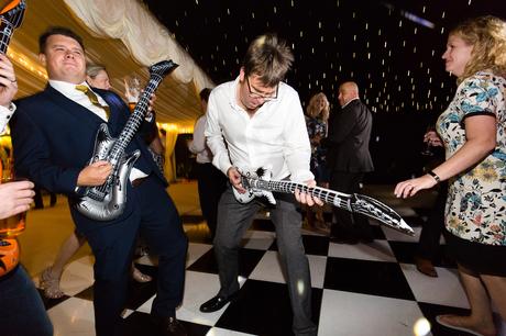 Guest playing blow up guitar at wedding