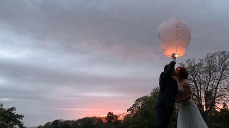 a bride and groom have a kiss before their chinese lantern floats off in to the beautiful sunset in Wyresdale Park