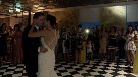 our newlyweds enjoy their first dance surrounded by friends and family at their wedding at On The 7th