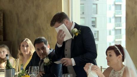 the groom wipes away his tears after an emotional part of his wedding speech 