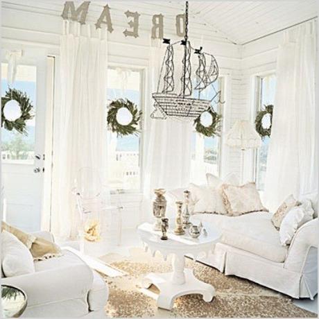 white living room decoration with beach concept design and white sofa also round coffee table with wreath on windows